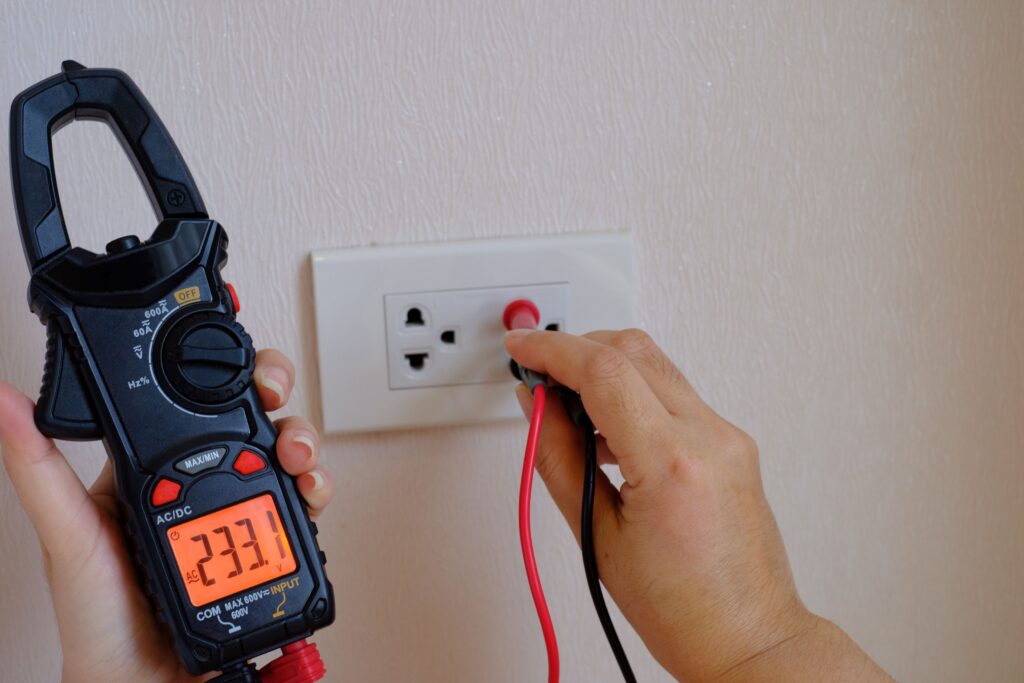 Licensed electrician in Balmain East inspecting power outlet using a tester