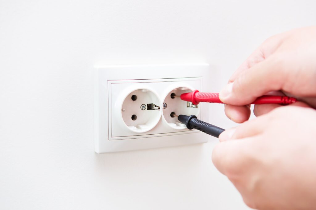 Electrician testing wall socket in Ashfield